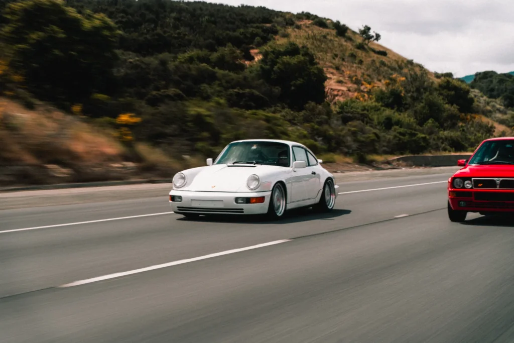 White Porsche 964 driving on a highway