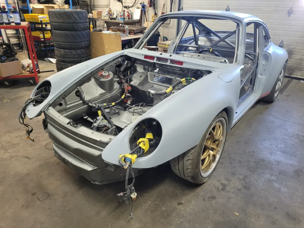 Porsche 911 shell with a roll cage during a track car build