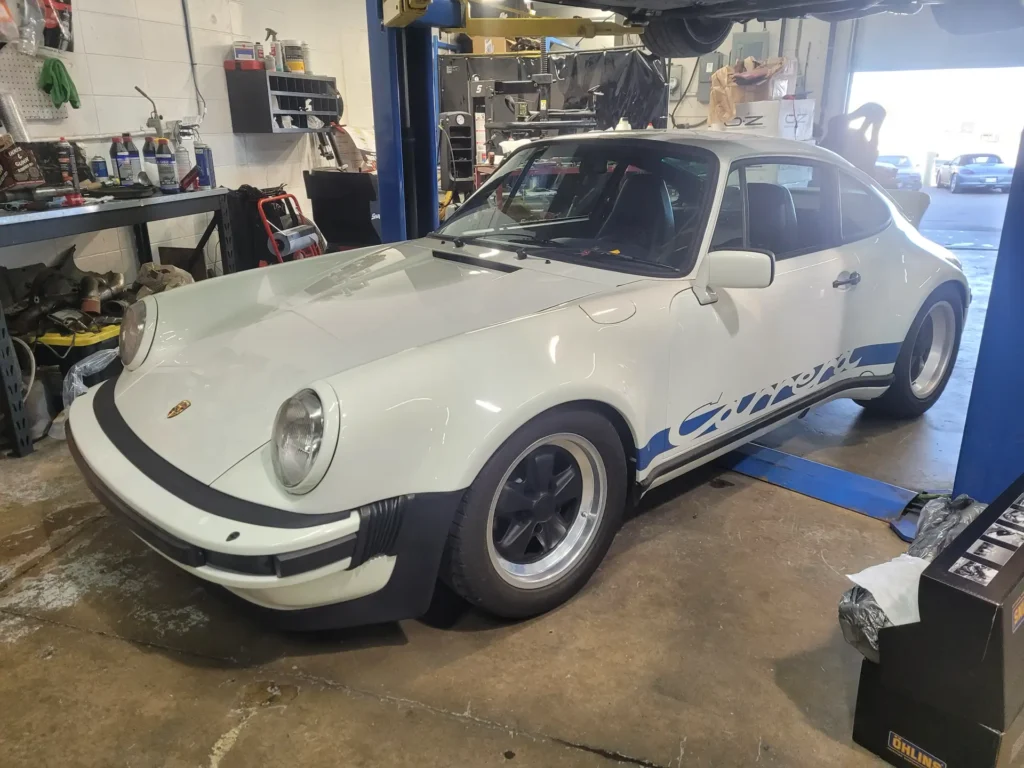 White Porsche 911 Turbo on a lift at Alpine Autowerks