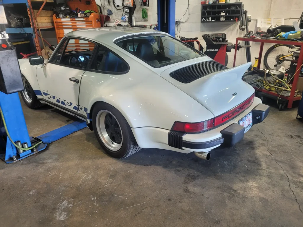 White Porsche 911 Turbo on a lift at Alpine Autowerks