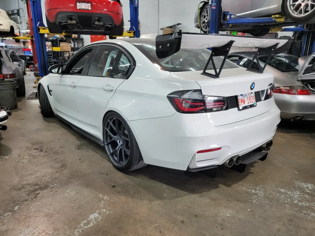 White BMW M3 with a rear wing in the shop