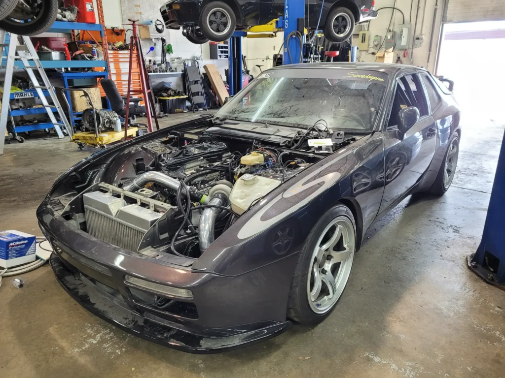 Porsche 944 with the hood removed in the Alpine Autowerks shop
