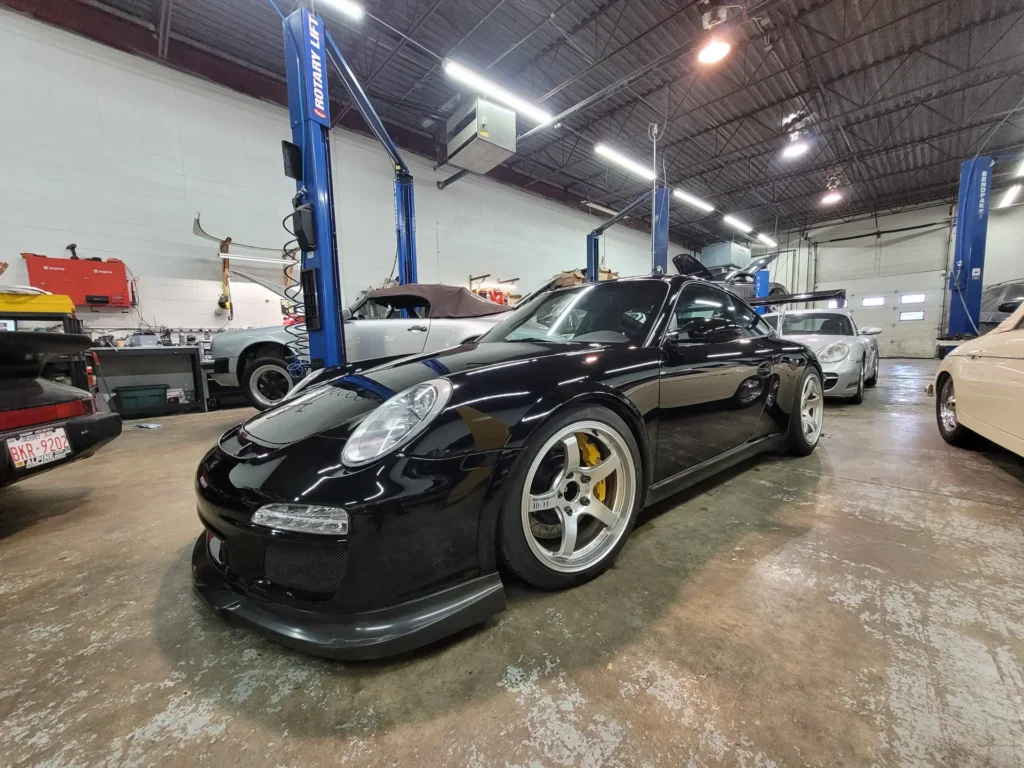 Black Porsche 911 with yellow brake calipers in the Alpine Autowerks shop