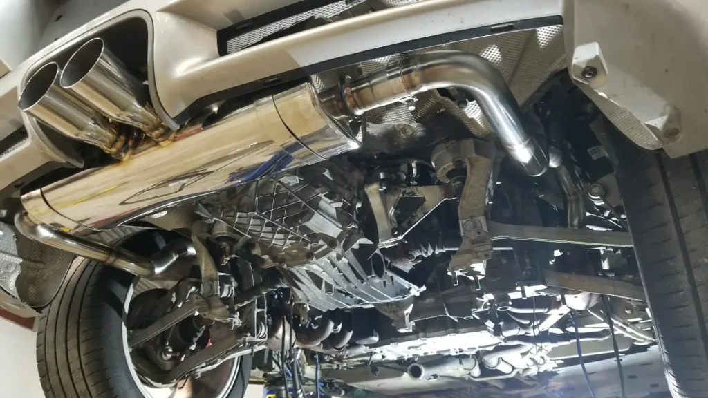 Polished exhaust and underside of a car on the lift