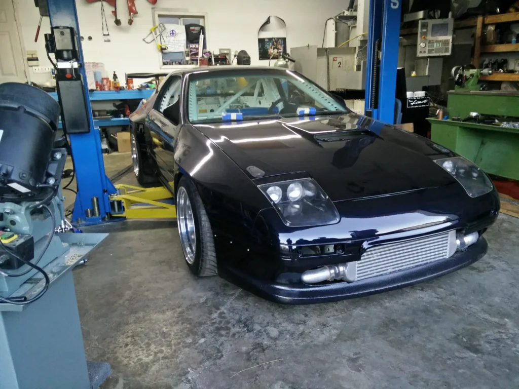 Dark blue coupe on a service lift at Alpine Autowerks