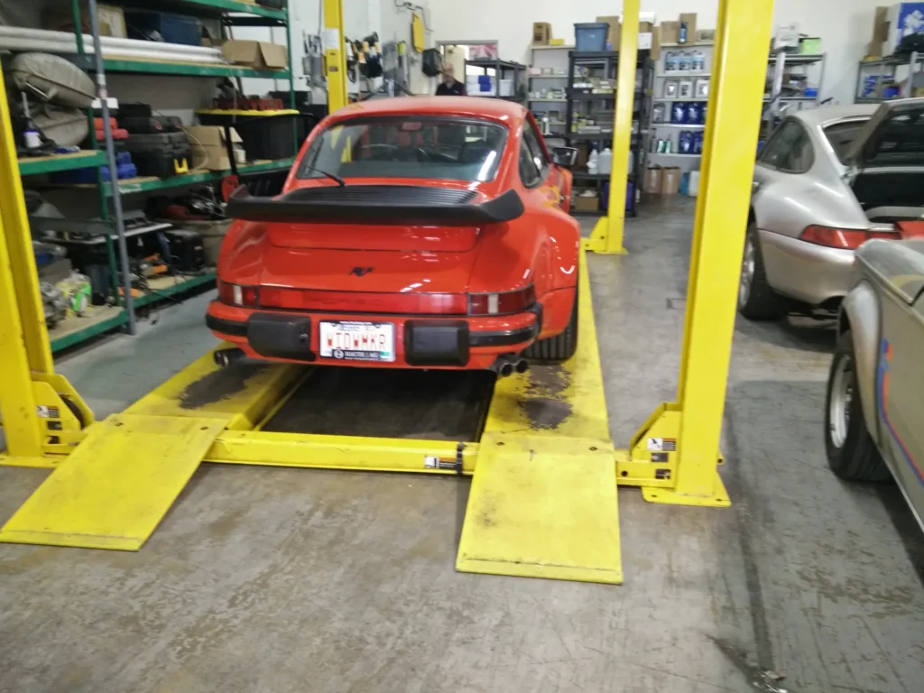 Red Porsche 911 Turbo on a four-post lift at Alpine Autowerks