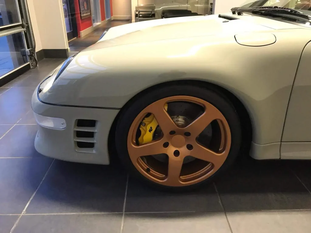 Bronze wheel and yellow brake caliper on a Porsche 911